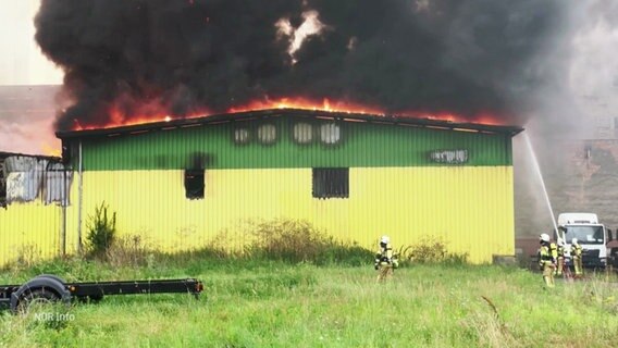 Eine brennende Lagerhalle wird von der Feuerwehr gelöscht. © Screenshot 