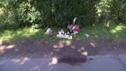 Blumen und Kerzen stehen am Straßenrand an der Unglücksstelle. © Screenshot 
