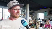 Daniel Lehrmann vom Mehrfisch in Eckernförde spricht in ein Mikrofon. © Screenshot 