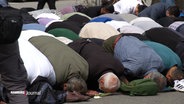 Männer treffen sich zum Freitagsgebet vor der blauen Moschee in Hamburg. © Screenshot 