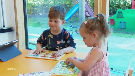 Zwei Kinder spielen an einem Tisch. © Screenshot 