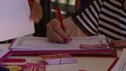 Eine Person unterschreibt eine Petition. © Screenshot 