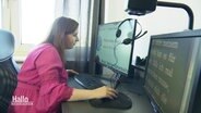 Eine Frau mit eingeschränkter Sehfähigkeit sitzt vor einem Bildschirm der einen vergrößerten Teil einer Website abbildet. © Screenshot 