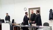 Angeklagter Polizist mit seinen Anwälten © Screenshot 