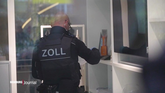 Ein Zollbeamter bei der Durchsuchung von einem Engel & Völkers Standort. © Screenshot 