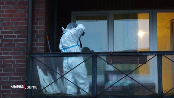 Eine Person in weißer Schutzkleidung fotografiert Spuren auf einem Balkon. © Screenshot 