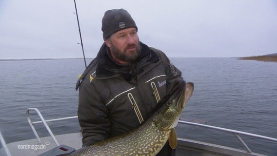 Ein Angler hält einen großen Hecht. © Screenshot 