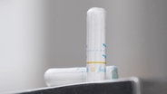 Ein Tampon steht auf einer Ablage. © Screenshot 