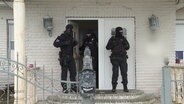Einsatzkräfte der Polizei bei einer Hausdurchsuchung. © Screenshot 