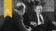 Der Journalist Joachim Besser interviewt am 09.03.1961 Nahum Goldman am Tisch sitzend. © Screenshot 