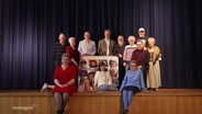 Die Darstellenden der Malchower Dilettanten-Bühne posieren für ein Gruppenfoto am Bühnenrand. © Screenshot 