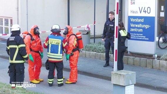 Einsatzkräfte der Feuerwehr tragen Schutzanzüge. © Screenshot 