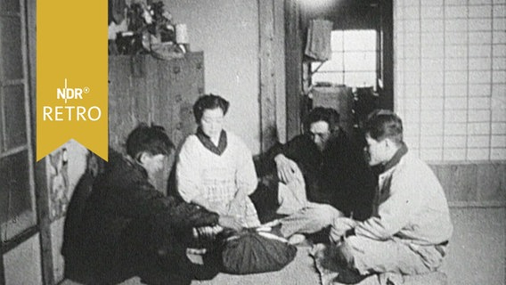 Japanische Fischerfamilie sitzt 1958 auf dem Boden ihres tradionellen Hauses. © Screenshot 