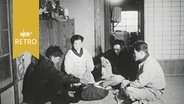 Japanische Fischerfamilie sitzt 1958 auf dem Boden ihres tradionellen Hauses. © Screenshot 