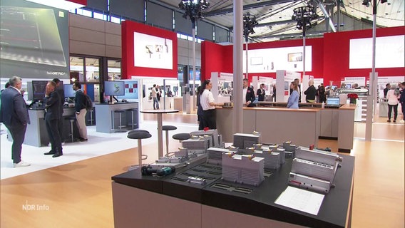 Besucher stehen an Messeständen auf der Hannover Messe. © Screenshot 