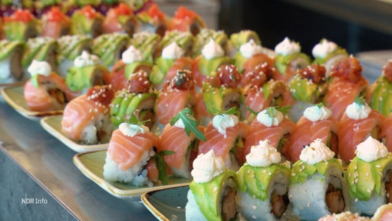 Sushi-Rollen sind auf mehreren Tellern angerichtet. © Screenshot 