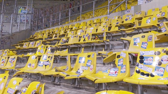 Blick auf eine Tribüne in einem Fußballstadion mit vielen zerstörten Plastiksitzen © Screenshot 