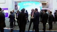 Eine Menschengruppe steht vor einem Airbus Messestand. © Screenshot 