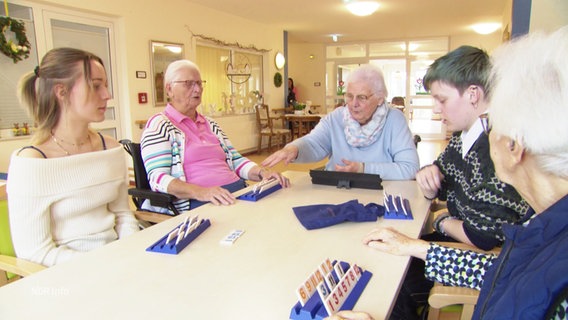 Juno und Julia spielen mit Pflegeheim-Bewohnerinnen ein Gesellschaftsspiel. © Screenshot 