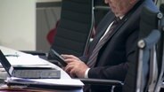 Ein Mann hält sein Smartphone in der Hand. © Screenshot 