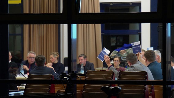 Menschen halten Stimmkarten hoch. © Screenshot 