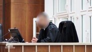 Ein mutmaßlich korrupter Staatsanwalt mit verpixeltem Gesicht in einem Gerichtssaal. © Screenshot 