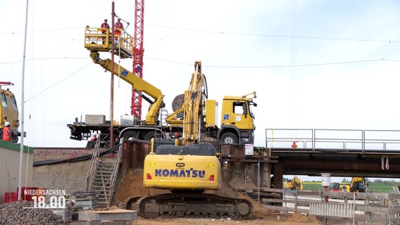 Arbeiter und Baumaschinen erneuern eine Bahnunterführung. © Screenshot 