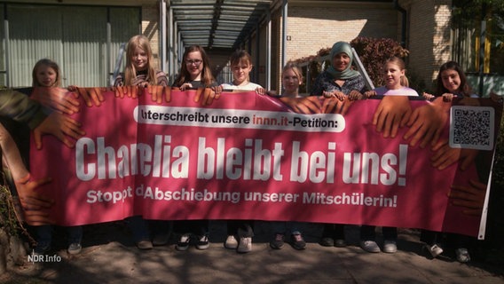 Schülerinnen halten ein Transparent mit der Aufschrift "Chamelia bleibt bei uns". © Screenshot 
