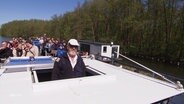 Ein Kapitän mit Fahrgästen auf seinem Schiff. © Screenshot 