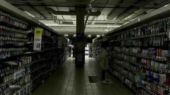 Eine Frau steht in einem dunklen Supermarkt. © Screenshot 