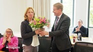 Die zukünftige Bildungsministerin Karin Prien wird im schleswig-holsteinischen Landesparlament mit einem Blumenstrauß verabschiedet. © Screenshot 