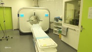 Ein Computertomograf steht in einem Behandlungsraum eines Krankenhaus. © Screenshot 