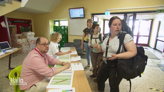 Besucherinnen des Kirchentages kommen in einer Schule an die zur Unterkunft umfunktioniert wurde . © Screenshot 