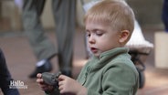 Ein Kind spielt mit einem Spielzeug-Nilpferd beim Kirchentag in Hannover. © Screenshot 
