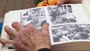 Eine Frau blättern in einem Fotoalbum mit alten Schwarz-Weiß-Fotos. © Screenshot 