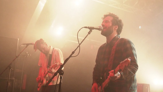 Zwei Mitglieder der Band "Herrenmagazin" auf einer vernebelten Bühne. © Screenshot 