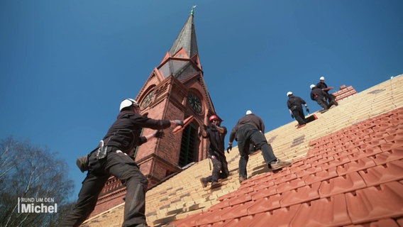 Dachdecker erneuern das Dach einer Kirche. © Screenshot 