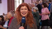 Reporter Sophie Mühlmann berichtet live vom 74-Stunden-Singmarathon in Hannover während des 39. Evangelischen Kirchentages 2025. © Screenshot 