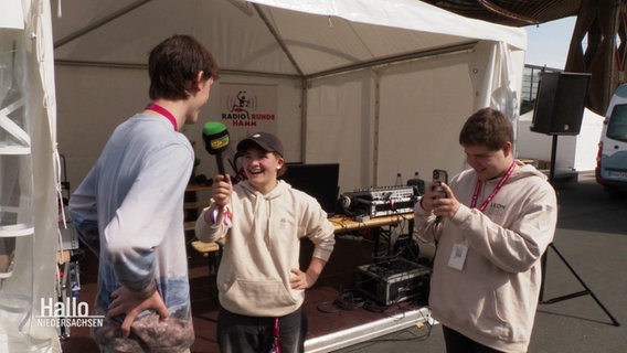 Nachwuchsreporter Jil und Leon von Radio Hitwave interviewen einen Besucher des 39. Evangelischen Kirchentages in Hannover 2025. © Screenshot 