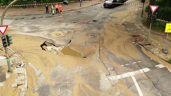 Eine Kreuzung in Hamburg-Eimsbüttel ist nach einem Wasserrohrbruch unterspült und die Fahrbahn abgesackt. © Screenshot 