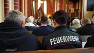 Feuerwehrleute bei einem Gottesdienst. © Screenshot 