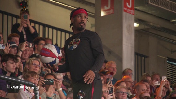 Ein Spieler der Harlem Globetrotters mit einem Basketball im Stadion. © Screenshot 