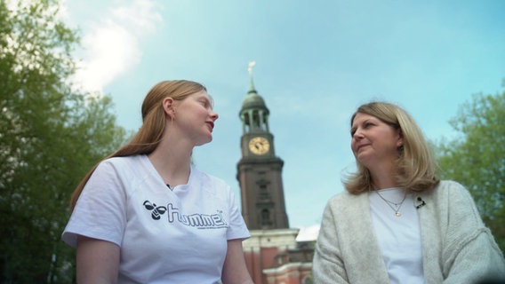 Zwei Frauen unterhalten sich. Im Hintergrund ist der Hamburger Michel zu sehen. © Screenshot 
