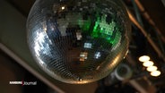 Eine Discokugel hängt unter einer Decke. © Screenshot 
