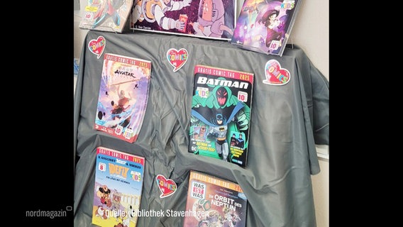Diverse Comics sind in einer Bibliothek ausgestellt. © Screenshot 