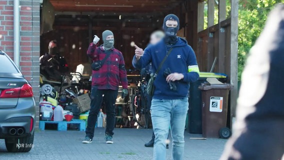 Polizeibeamte führen eine Hausdurchsuchung durch. © Screenshot 