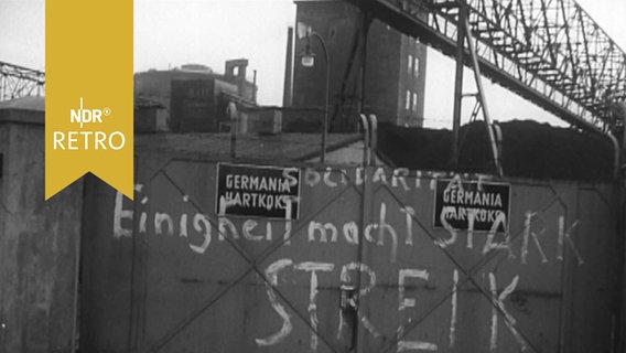 Parole zum Streik im Öffentlichen Dienst 1954 an einem geschlossenen Werkstor. © Screenshot 