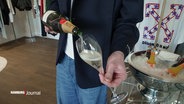Ein sogenannter "Personal Shopper" schenkt für einen Kunden ein Glas voll Champagner. © Screenshot 