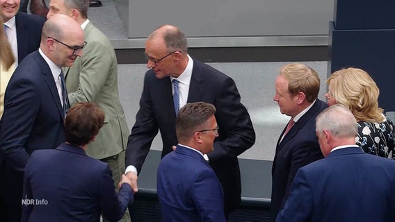 Andere Bundestagsabgeordnete gratulieren Friedrich Merz nach seiner Wahl zum deutschen Bundeskanzler im zweiten Wahlgang. © Screenshot 
