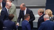 Andere Bundestagsabgeordnete gratulieren Friedrich Merz nach seiner Wahl zum deutschen Bundeskanzler im zweiten Wahlgang. © Screenshot 